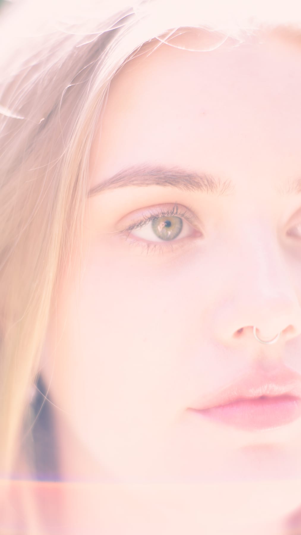 Soft, pale close-up of a woman's face.